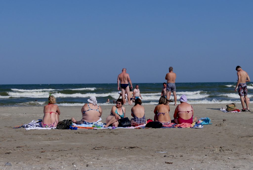 șir de femei care stau pe plaja din Sfântu Gheorghe