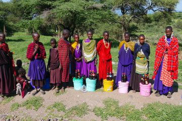 Femei și copii masai stau aliniați și pozează